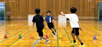 金沢市教室にておにごっこをして走っている３人の子供