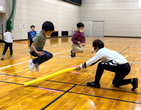 小松市教室にて反応ジャンプをする男の子二人と指導する大久保先生