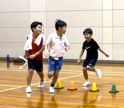 楽しそうに鬼ごっこをする３人の小学三年生の子供