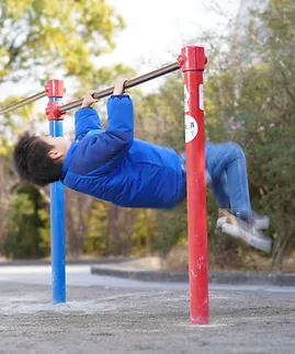 鉄棒で逆上がりを練習する男の子