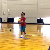 ドッジボールでキャッチができて喜ぶ幼児の男の子