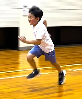 笑顔で走り方の練習をする男の子