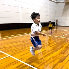 加賀市教室にて、楽しそうにあやとびをする小学生の男の子供