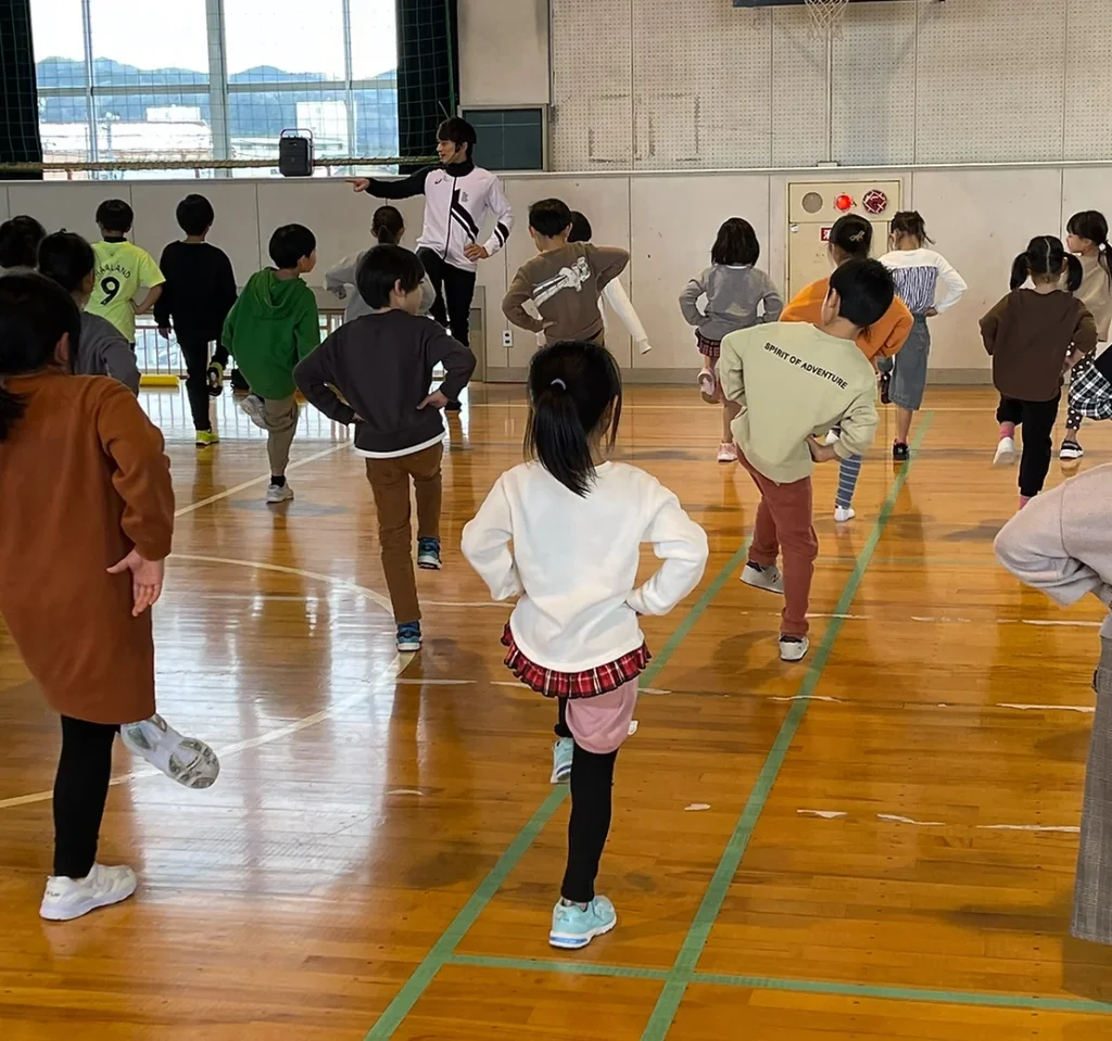 大勢の子供たちに「片足バランス」を指導する大久保先生