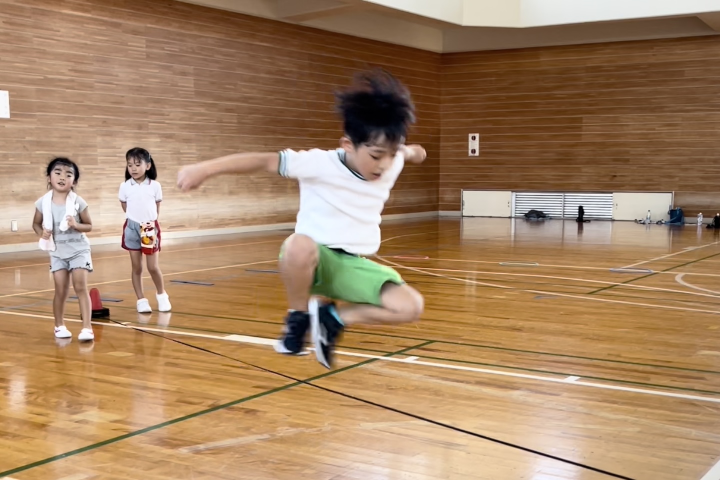 福井市教室にて、オリジナルの運動神経トレーニング「ゴム跳びジャンプ」をするかっこよくする幼児の男児