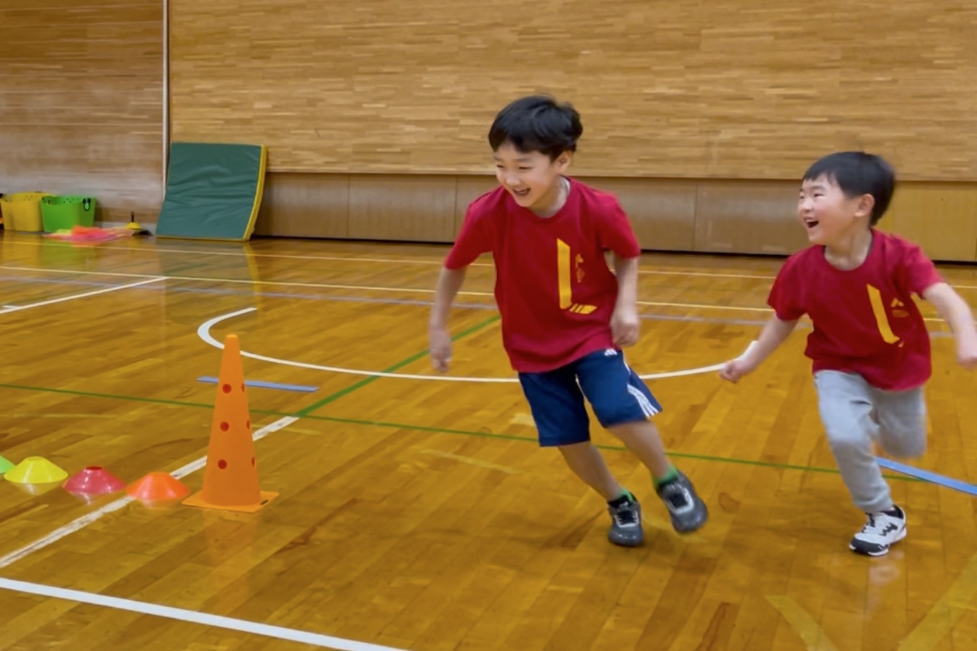 福井市教室にて、満遍の笑顔で鬼ごっこをする幼児の子供